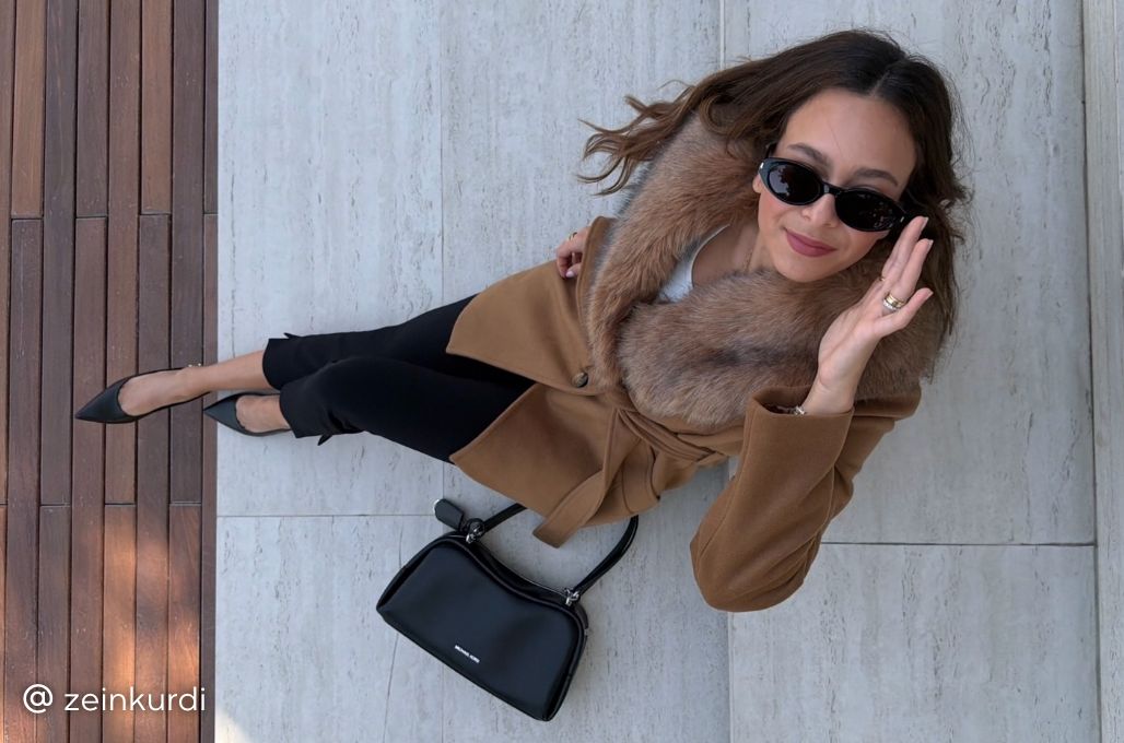model wearing brown fur coat and black handbag