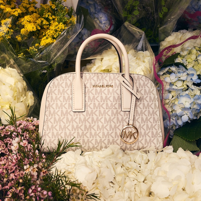 bolso de mano ashton de piel en tono crema sobre ramos de flores