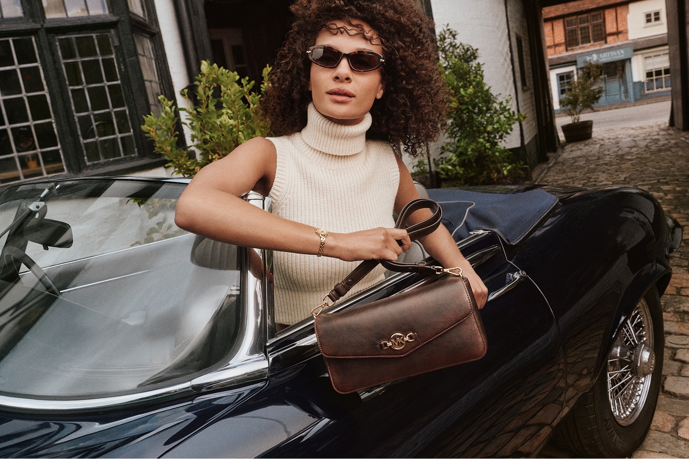 modelo en auto con un bolso en la mano