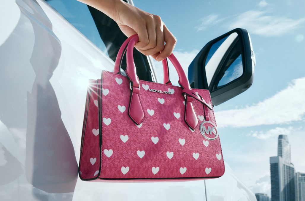 mannequin tenant un sac &agrave; main rose &agrave; motif de c&oelig;urs blancs