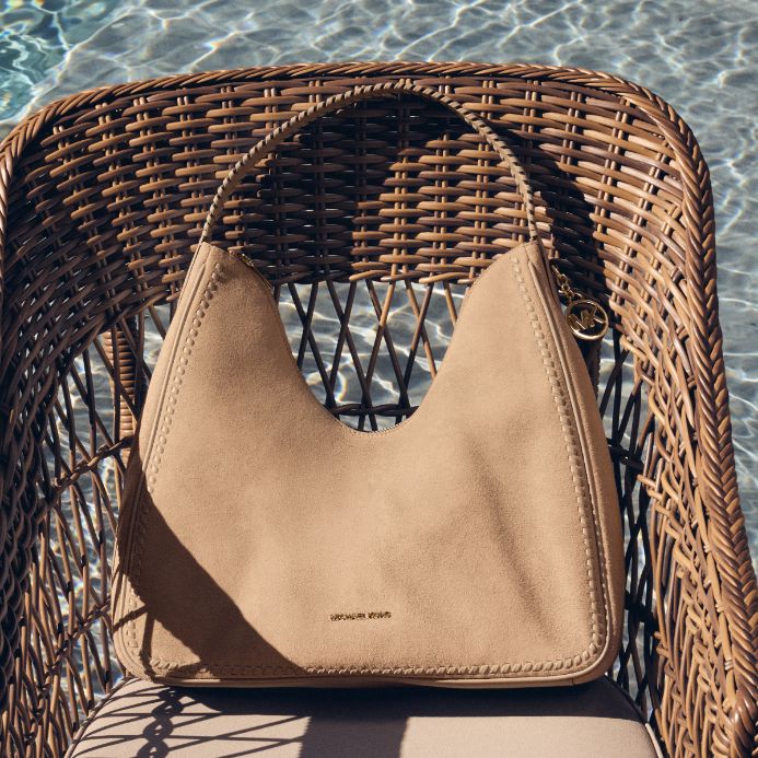 brown suede handbag on wicker chair in swimming pool