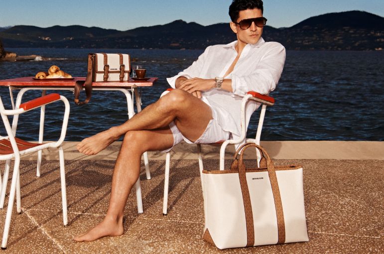 model in white linen shirt with cream and brown satchel