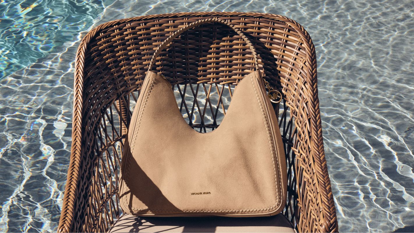 tan suede handbag on wicker chair in swimming pool