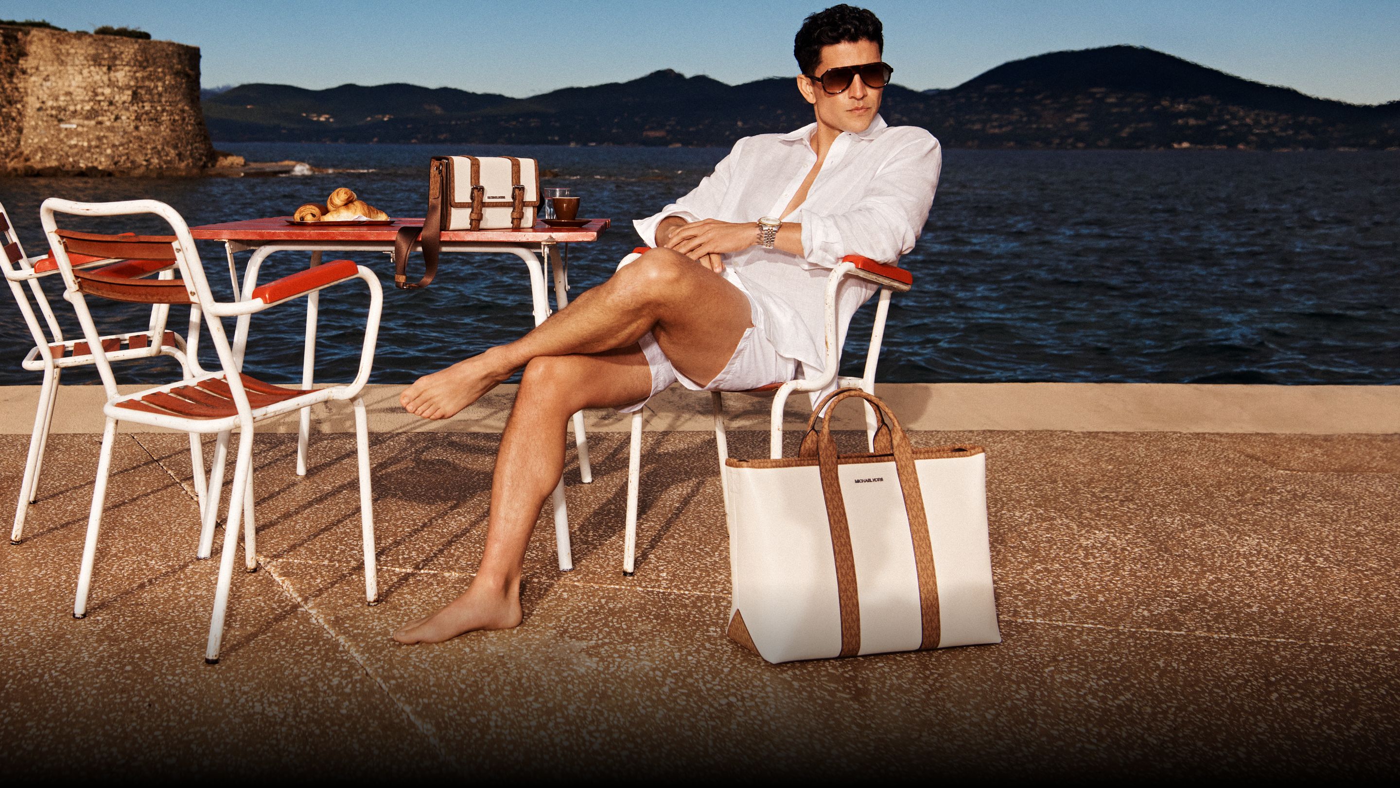 model in white linen shirt with cream and brown satchel