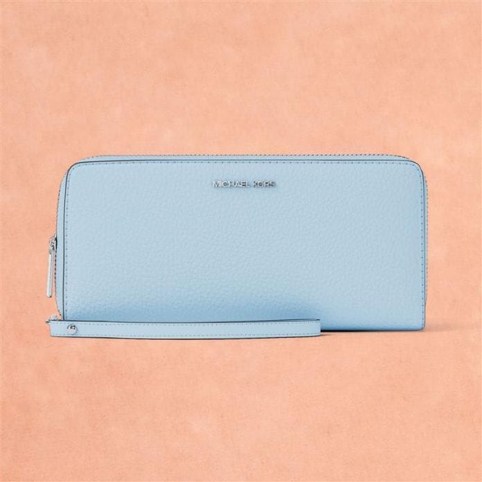 blue leather logo wristlet on peach background