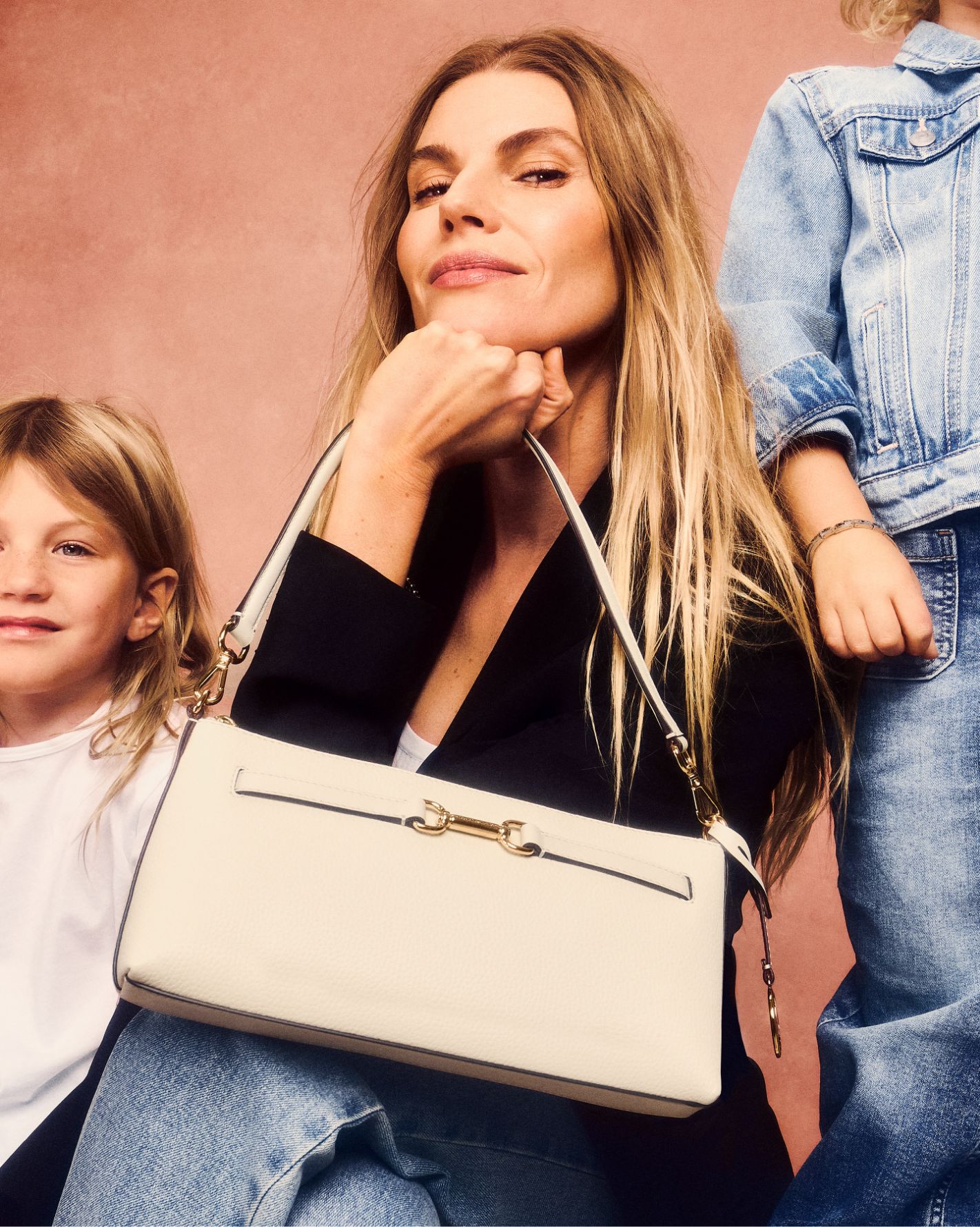mother and children holding cream leather handbag