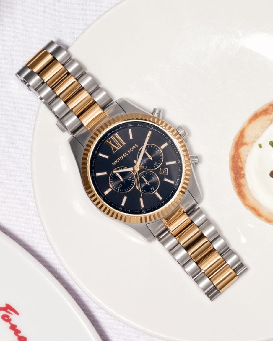 silver and gold tone watch on a plate