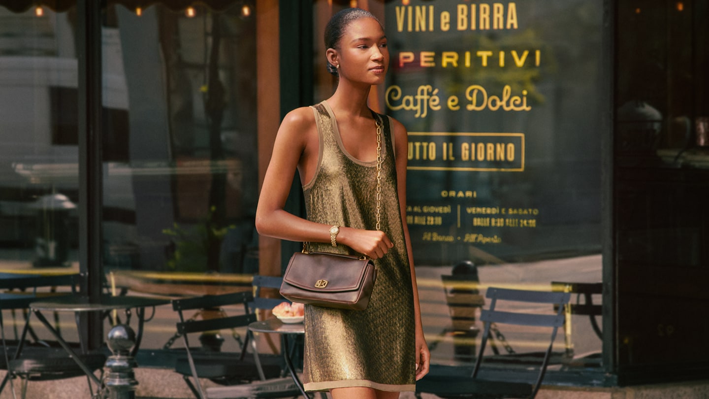 model wearing green dress and burnished leather handbag