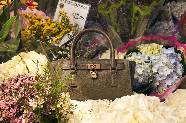 olive green leather handbag in bouquets of flowers