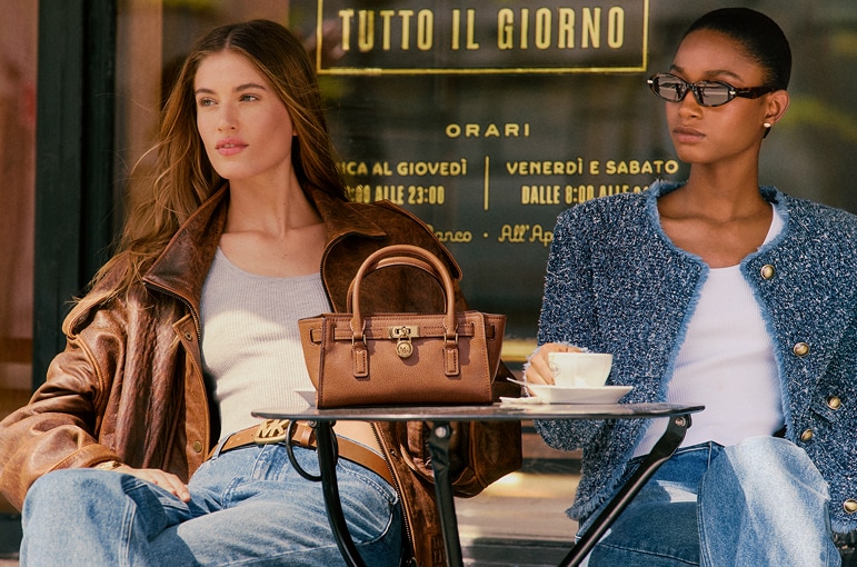 mannequins assises &agrave; une table avec un sac &agrave; main en cuir brun