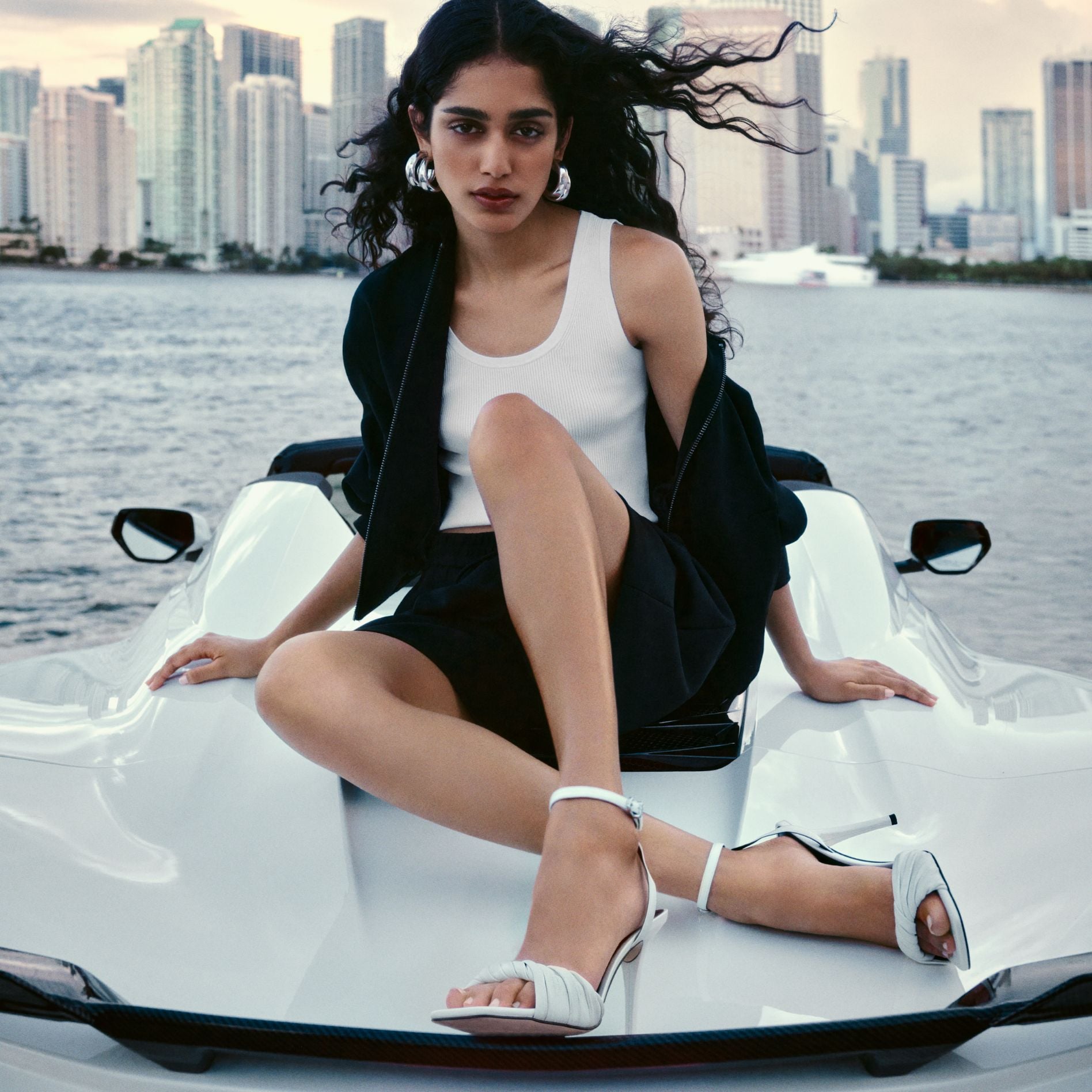 model on a jet-ski wearing michael kors clothing and sandals