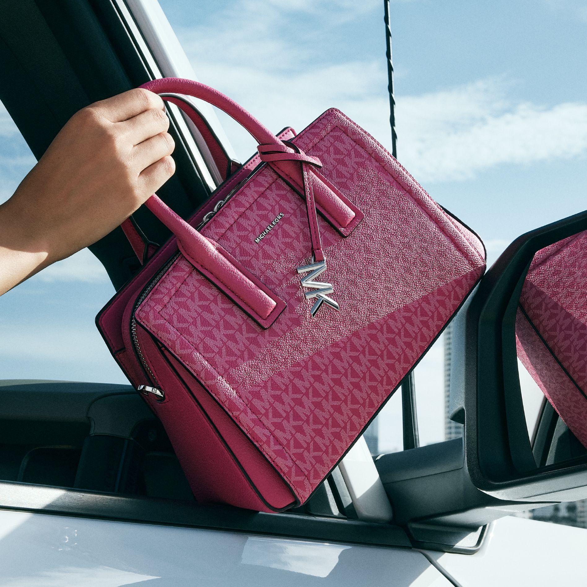 model with pink signature print handbag