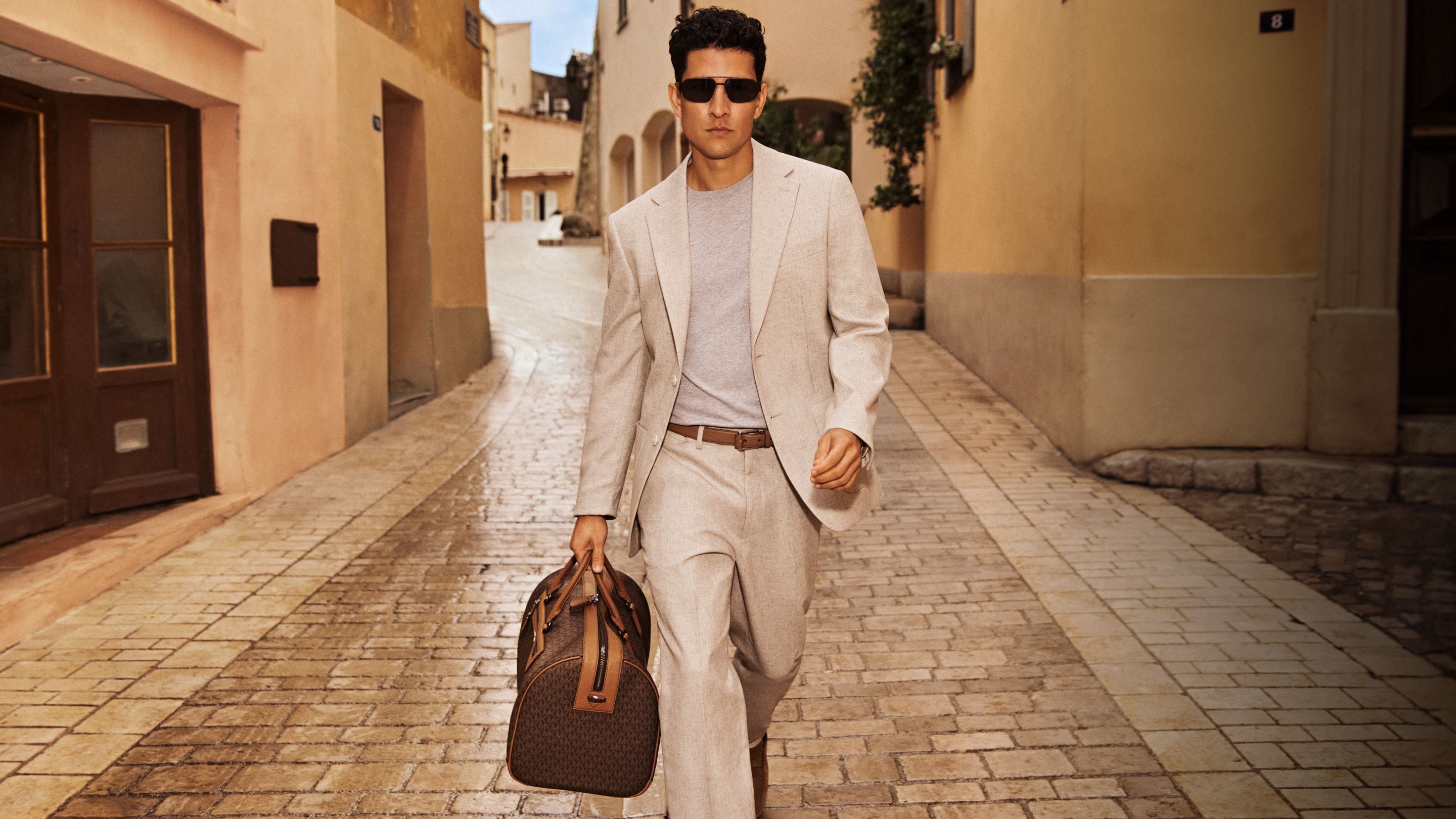 model in cream blazer and pants with duffel