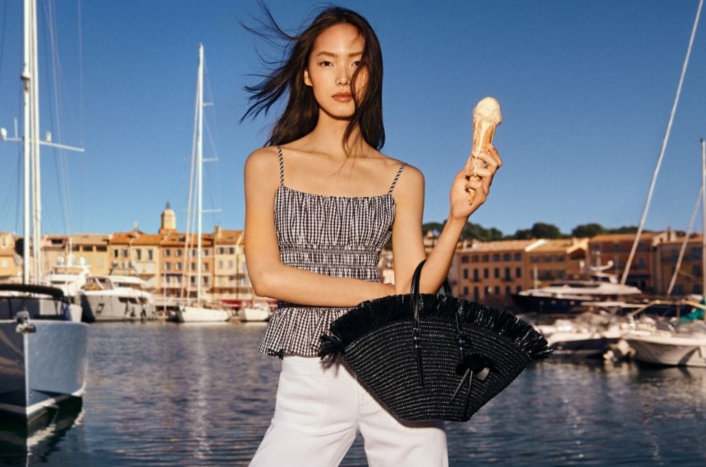 model with a black straw handbag