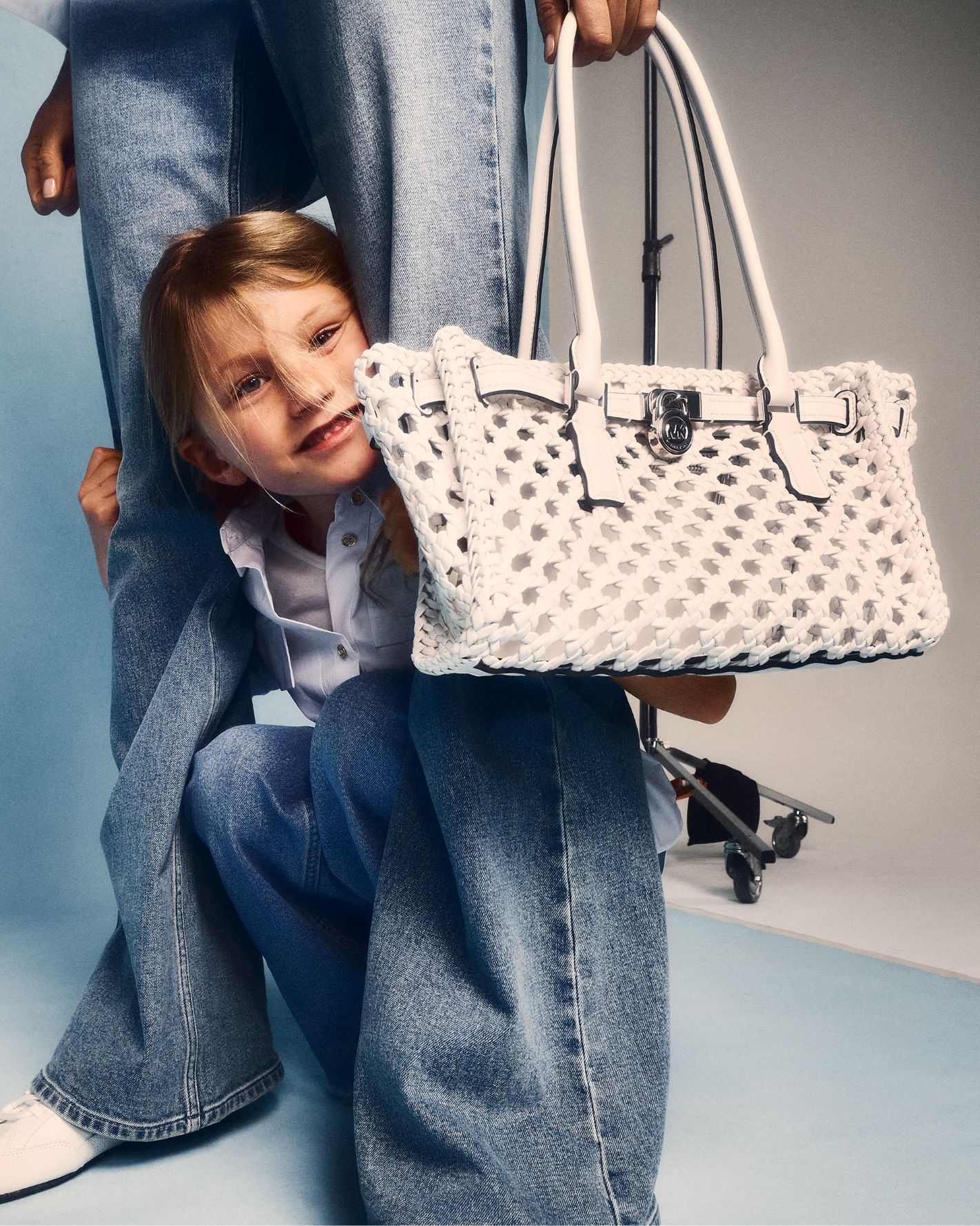 daughter in between mom's legs with white handbag