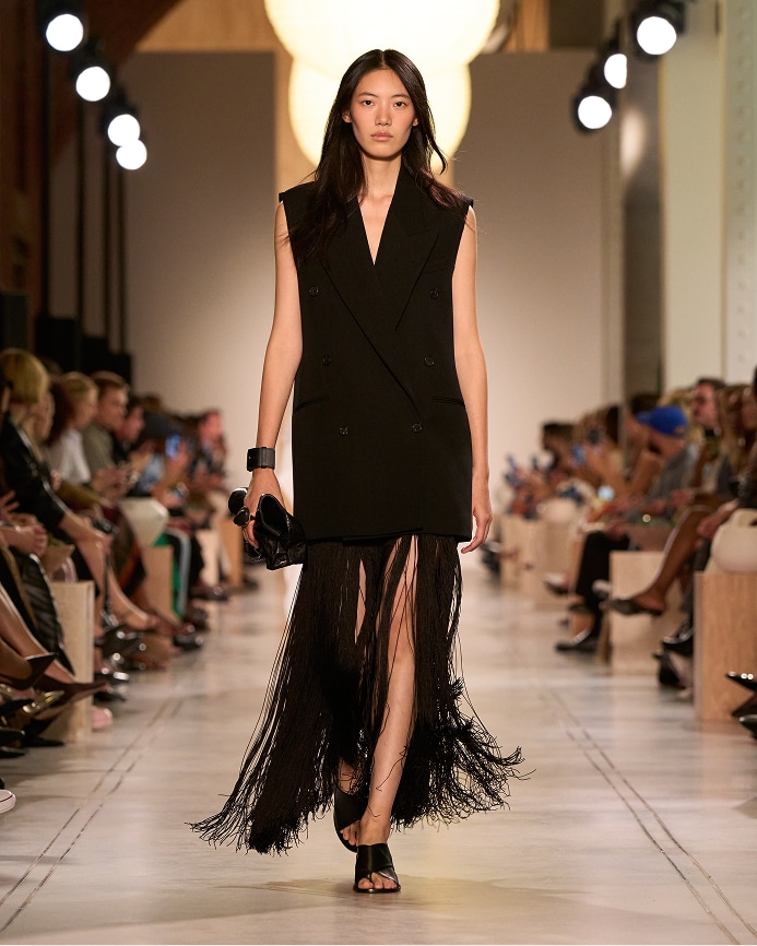 modelo con vestido con flecos en tono negro
